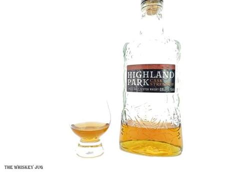 White background tasting shot with the Highland Park Cask Strength bottle and a glass of whiskey next to it.
