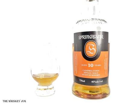 White background tasting shot with the Springbank 10 Years bottle and a glass of whiskey next to it.