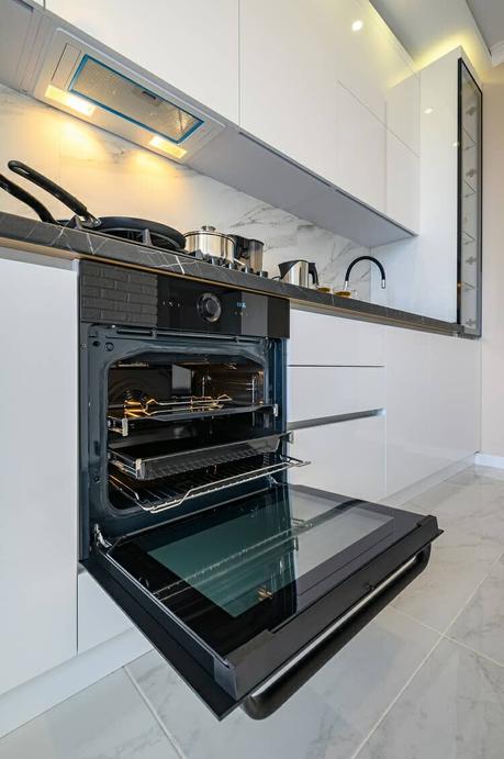 an oven door open in a white kitchen