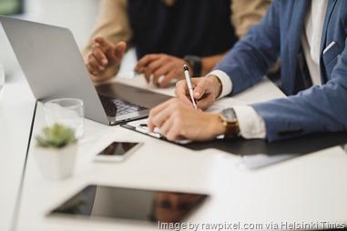 Office workers checking papers with pen in office