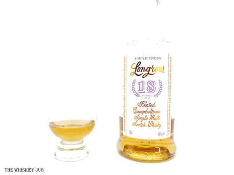 White background tasting shot with the Longrow 18 Years bottle and a glass of whiskey next to it.