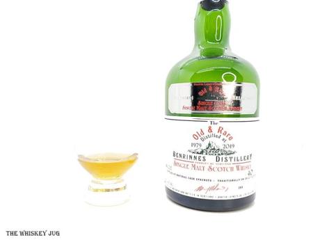 White background tasting shot with the 1979 Old and Rare Benrinnes 40 Years bottle and a glass of whiskey next to it.