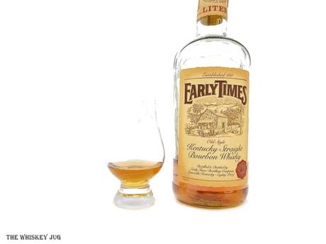 White background tasting shot with the Early Times Bourbon (1985) bottle and a glass of whiskey next to it.