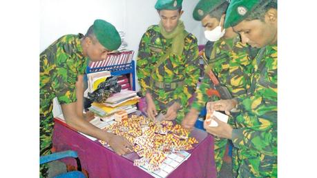 Police Special Task Force inspecting the haul of  intoxicant tablets seized.