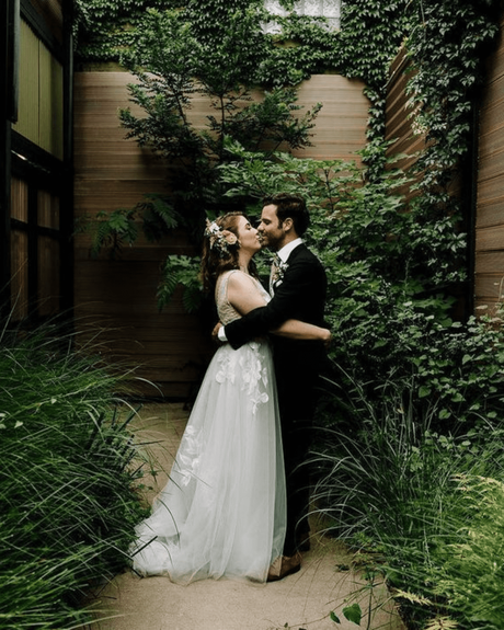 best wedding venues in new york newlyweds kissing near greenery