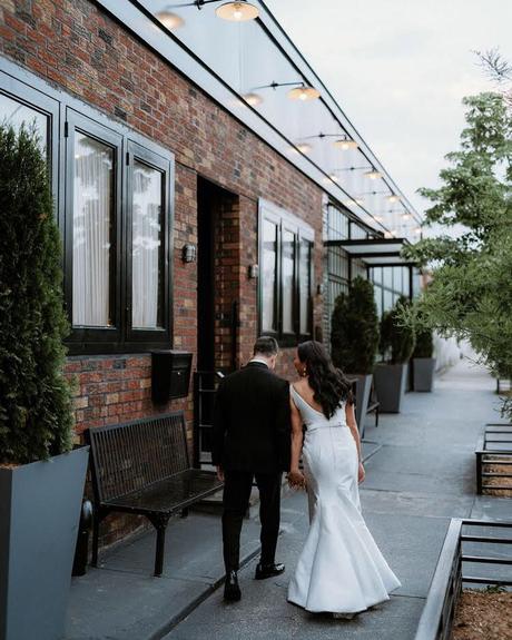 best wedding venues in new york newlyweds walking near the building