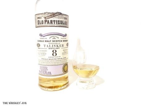 White background tasting shot with the 2009 Old Particular Talisker 8 Years bottle and a glass of whiskey next to it.