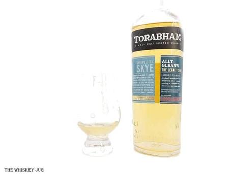 White background tasting shot with the Torabhaig Allt Gleann bottle and a glass of whiskey next to it.