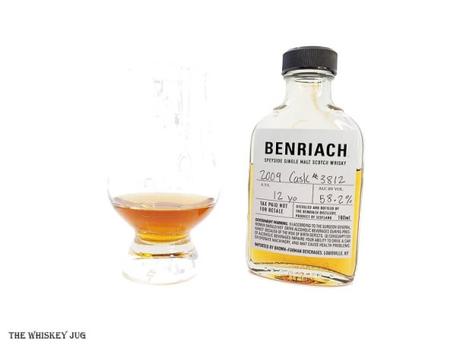White background tasting shot with the BenRiach 12 Years - 2009 Cask 3812 sample bottle and a glass of whiskey next to it.