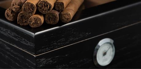 Cigars on top of a black humidor