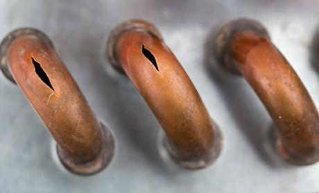 Close up image of burst copper pipes from cold