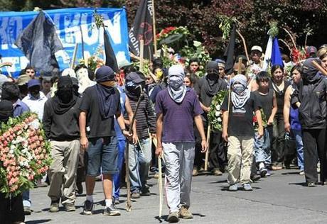 Militant Mapuches march at a funeral of one of their comrades.