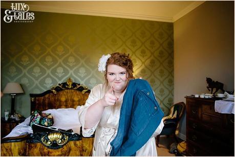 Bride makes silly face holding trousers at Grays Court wedding in York