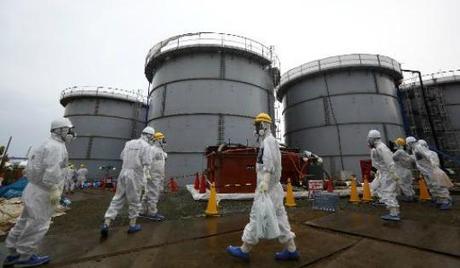 TEPCO employees wearing protective suits and masks walk past storage tanks for radioactive water at the Fukushima Dai-ichi nuclear power plant in Okuma, Fukushima Prefecture, Japan on November 7, 2013. (Photo: Pool/AFP/File, Tomohiro Ohsumi)