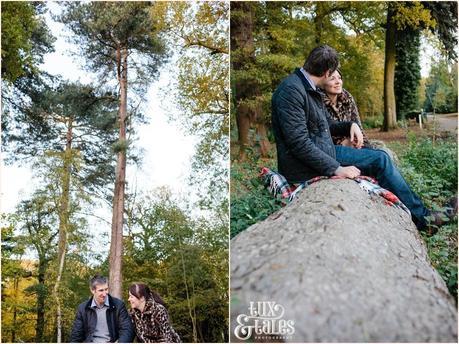 Autumn engagement shoot at elvaston castle couple sitting on a felled tree