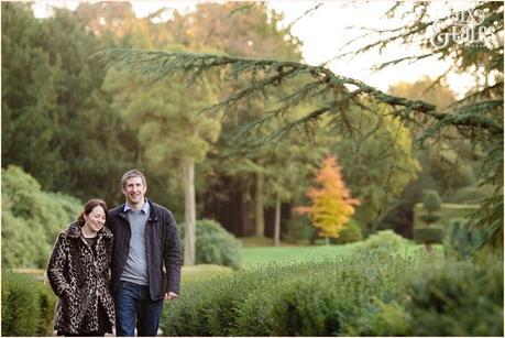 couple walks in low autumn light at elvaston castle engagement shoot