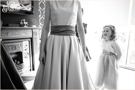 Little girl watches as bride gets her dress on at Swanland Wedding