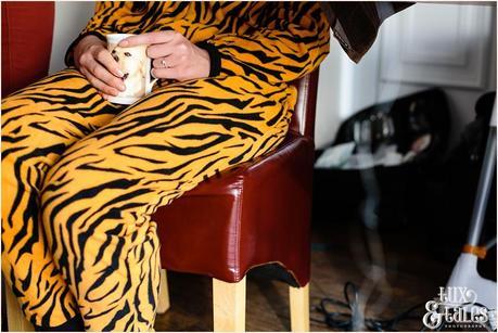 Bride in tiger onsie holds mug with picture of labrador