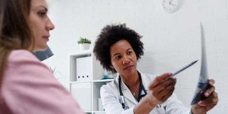 A doctor with a patient. Some critics say that certain physician positions went unfilled recently in part because infectious disease fellowship programs expanded too rapidly in the past several years.