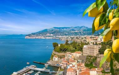 Aerial view of cliff coastline Sorrento and Gulf of Naples, Italy. Ripe yellow lemons in foreground. In Sorrento lemons are used in production of limoncello.