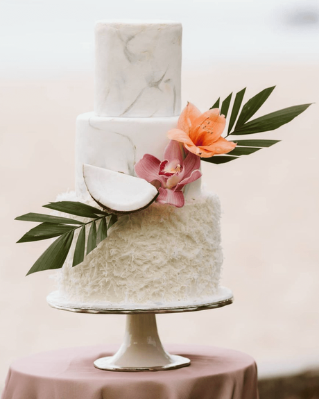 beach wedding three layered cake with tropical flowers