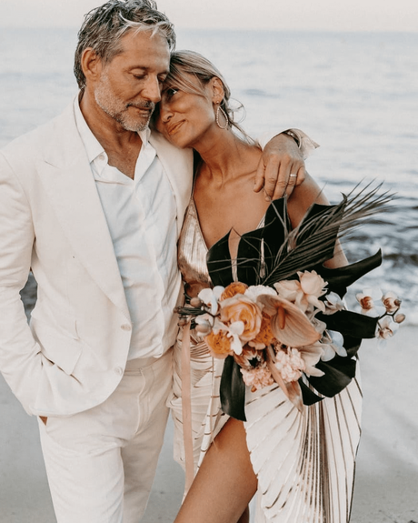 beach wedding groom and bride with bouquet with tropical flowers