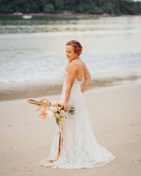 beach wedding bride by the sea holding bouquet