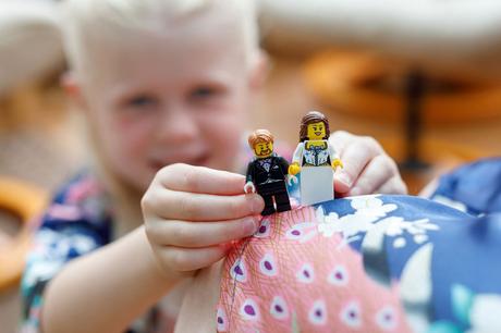 a flowergirl hold a lego bride and groom