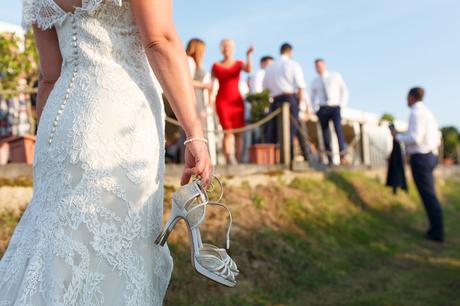 a bride holding her wedding shoes