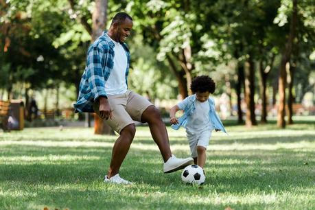 Picture of father and child playing soccer during mosquito season