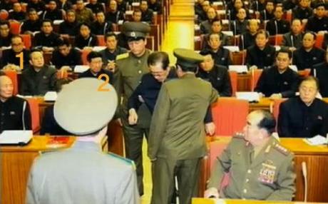Senior DPRK officials observe Jang's removal from the 8 December 2013 meeting: Joint Venture and Investment Commission Vice Chairman and Senior Deputy Director of the KWP Organization Guidance Department Ri Chol (1) and Deputy Director of the KWP Organization Guidance Department Hwang Pyong So (2) (Photo: KCTV screen grab).