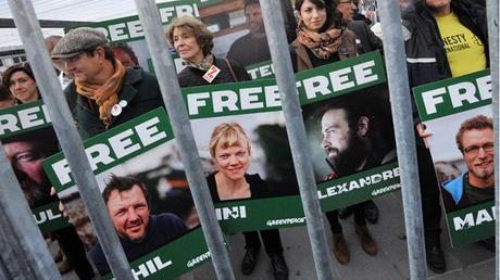 Honorary President of non-profit organisation ATTAC, Susan George (Center L), holds a sign bearing the portrait of a jailed Greenpeace activist alongside other protesters taking part in a demonstration calling for the release of a group of Greenpeace activists imprisoned in Russia, on October 31, 2013, in Paris. (AFP Photo / Pierre Andrieu)