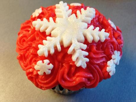 red piped buttercream swirls with white fondant snowflake star shaped and sugar sprinkles for christmas childrens ideas
