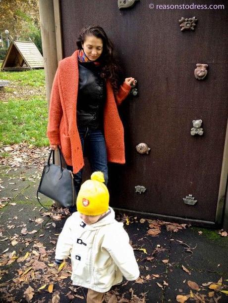 Stay Stylish When It’s Cold Outside with a Coatigan A cardigan sweater that can be worn as a coat heavy sweater orange coatigan cardigan-coat gray purse, young toddler with yellow pompom hat playground Modena Italy Italia reasonstodress.com