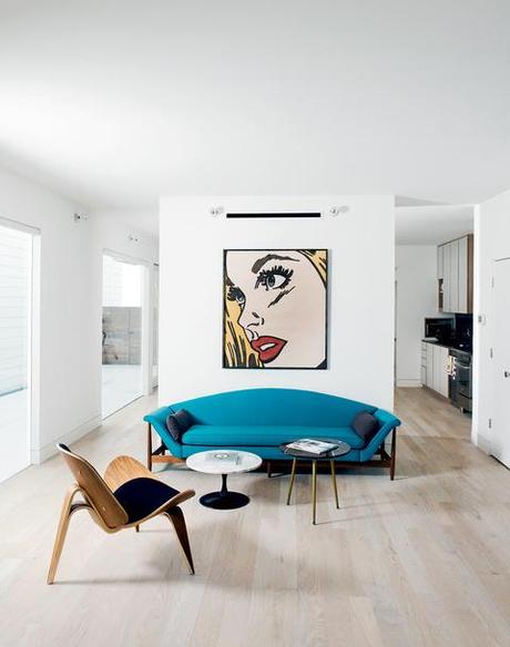 Modern living room with blue curved sofa and Mitch McGee print