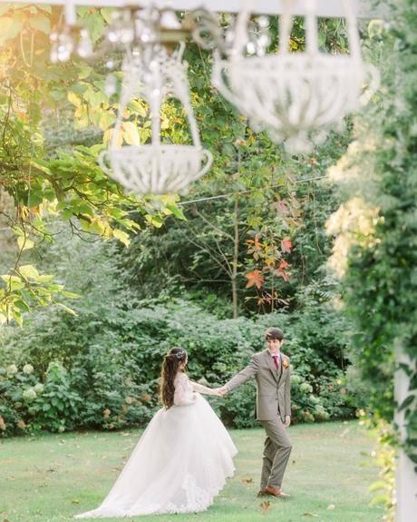 best wedding venues in michigan groom and bride walking in the woods