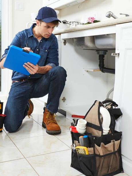 plumber checking under a sink