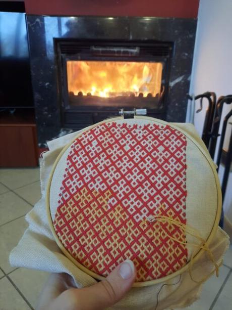 Making a German brick stitch embroidered purse: embroiderying in front of my parents' fireplace