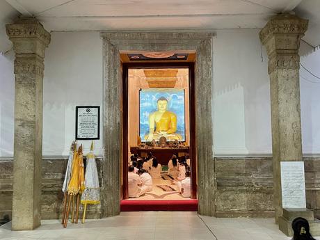 buddhists-wearing-white-praying-in-front-of-a-large-buddha-statue