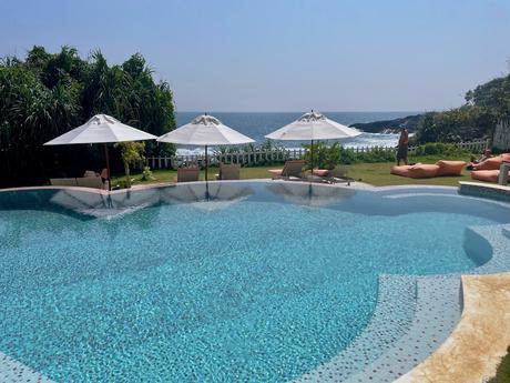 big-pool-with-white-umbrellas-and-sea-beyond-at-belika-beach-resort-hiriketiya