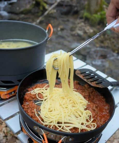 cooking food on a camping stove outside