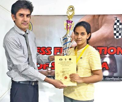 CFSL Vice President Thusha Wickramarachchi presents a trophy and certificate to women’s Amateur Chess Champion Dhihansa Gamage (right).     