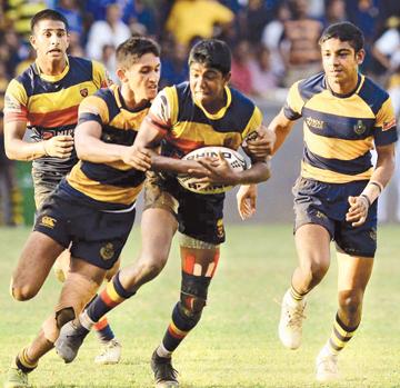 A Trinity player is well tackled by Royalist Philio Calyaneratne    (Pix by Suluchana Gamage)     