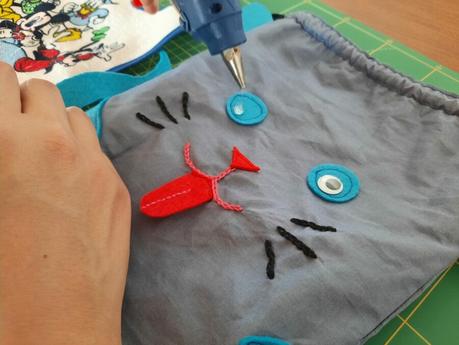 The final touches on my cat bag: glueing the googly eyes