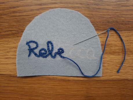 Embroiderying my daughter's name on the belly of her cat bag