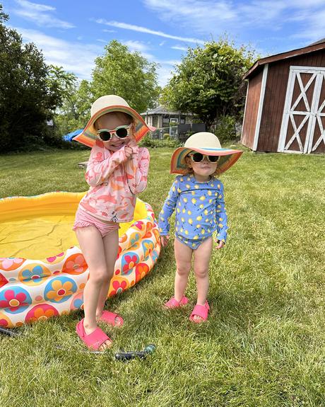 two girls standing by pool in backyard