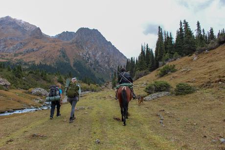 Nomadic-farmer-on-horseback-with-two-hikers-in-kyrgyzstan