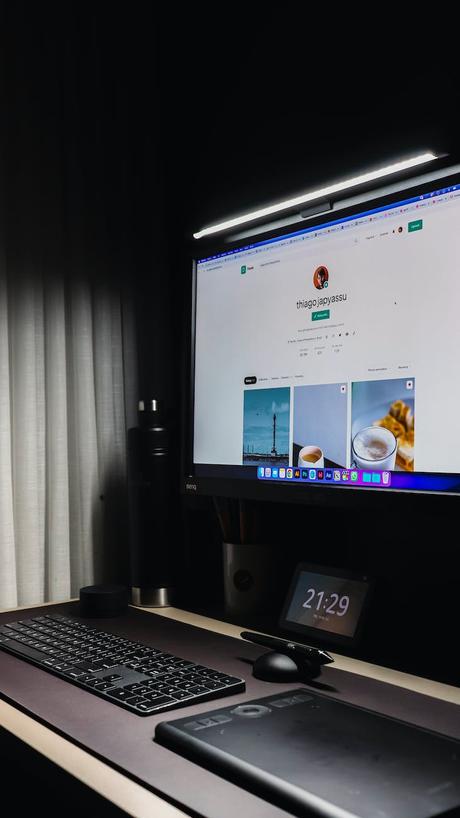 black flat screen computer monitor turned on near white window curtain