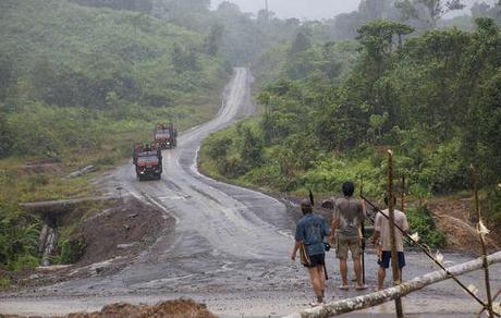 Penan armed with blowpipes block road as Shin Yang logging trucks approach, during a previous blockade.