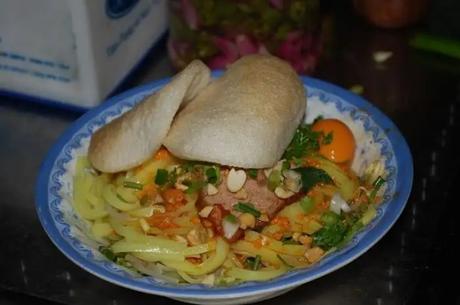 Bowl of rice noodles, shredded pork, bean sprouts, and croutons